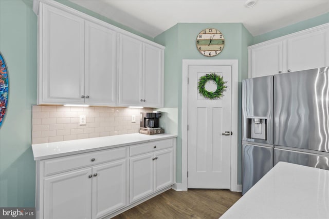 kitchen with stainless steel fridge with ice dispenser, light countertops, tasteful backsplash, and white cabinets