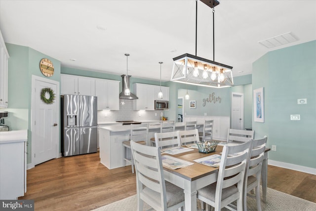 dining area featuring dark wood-style floors and visible vents