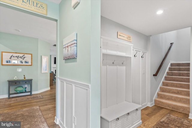 mudroom with wood finished floors, wainscoting, and recessed lighting