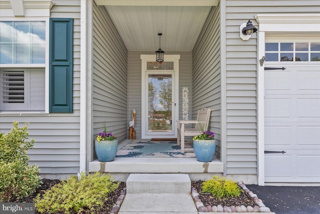 entrance to property featuring a porch and an attached garage