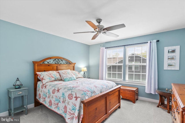 bedroom with light carpet, baseboards, and a ceiling fan
