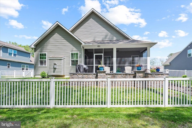 back of property featuring a sunroom, fence private yard, and a lawn