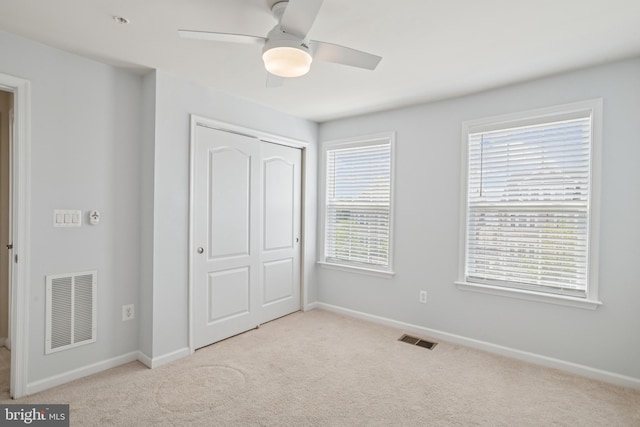 unfurnished bedroom featuring visible vents, carpet floors, and a closet