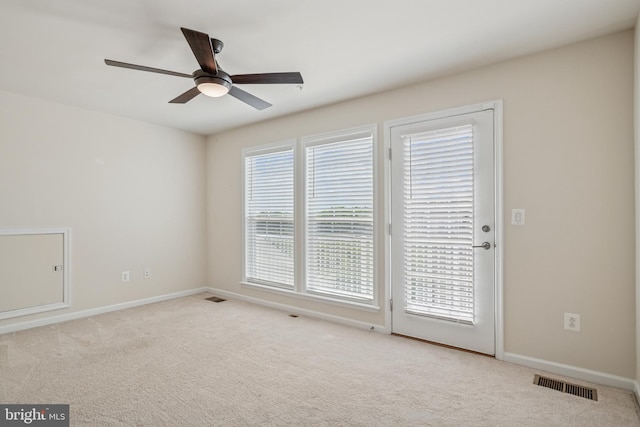 unfurnished room featuring carpet flooring, visible vents, and a healthy amount of sunlight