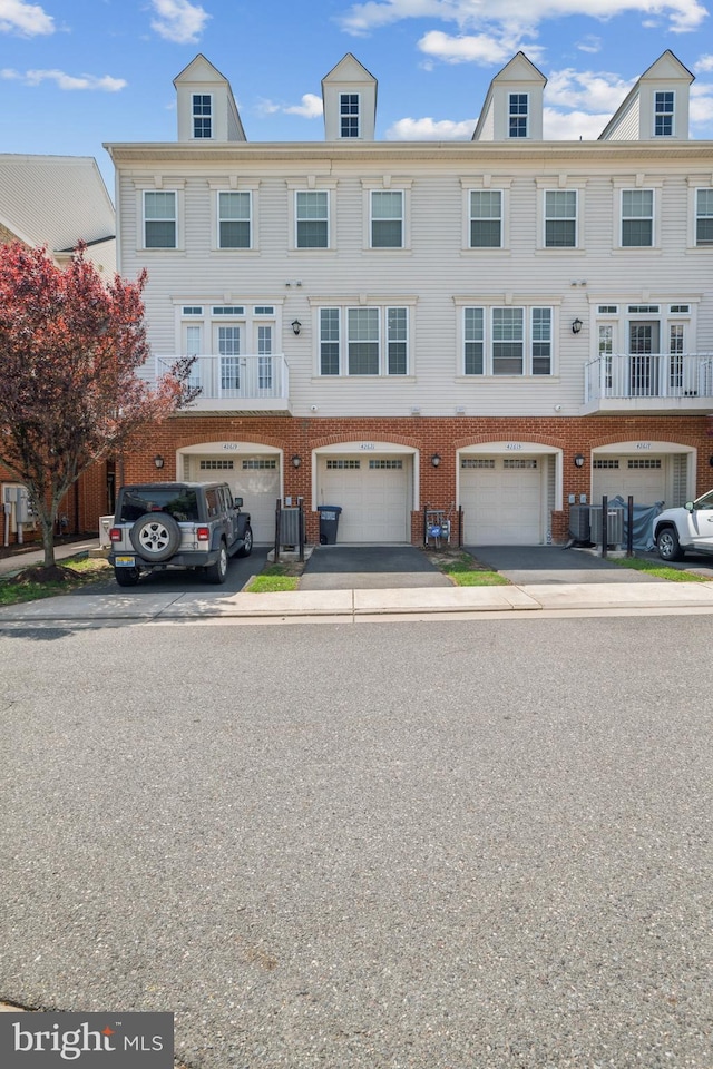 view of property featuring a garage, driveway, and brick siding