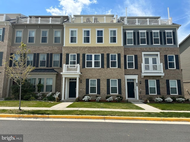 townhome / multi-family property with a front lawn and a balcony