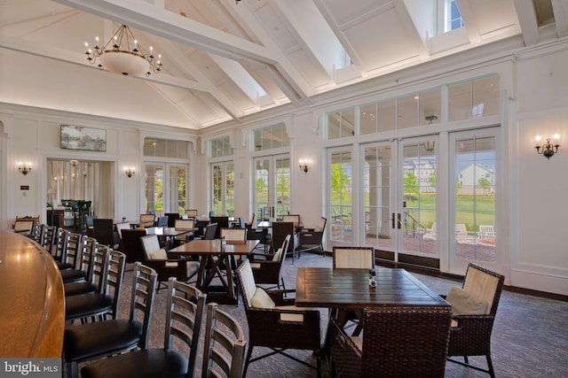 sunroom / solarium featuring french doors, beam ceiling, and a chandelier