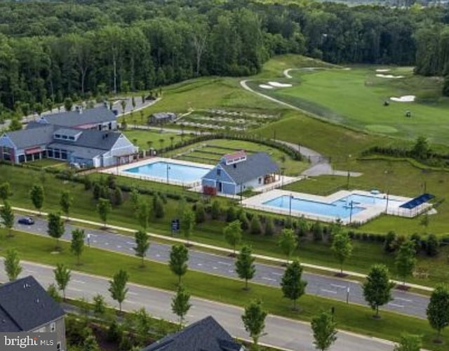 aerial view featuring view of golf course and a wooded view