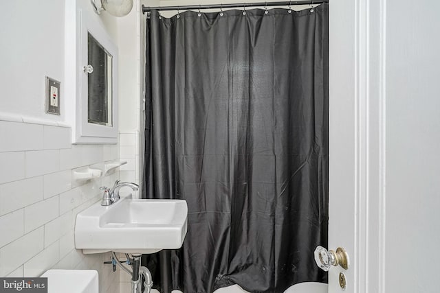 full bath featuring a sink, tile walls, a shower with curtain, and toilet