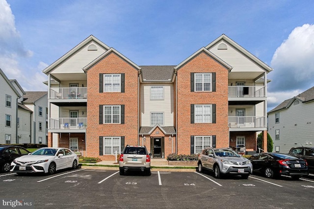 view of front of house featuring brick siding and uncovered parking