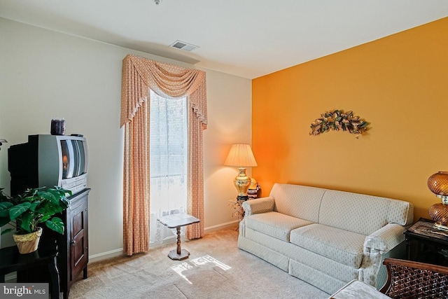 carpeted living area with baseboards and visible vents