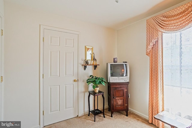 sitting room featuring baseboards and light colored carpet