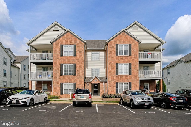 exterior space featuring brick siding and uncovered parking