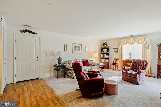 living room featuring visible vents and wood finished floors