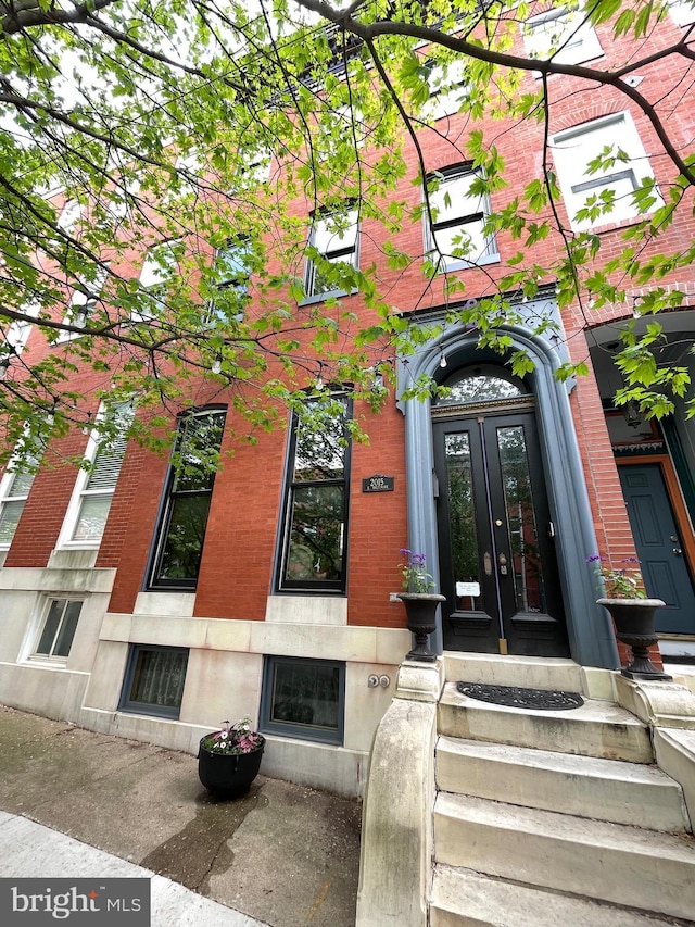 view of exterior entry with french doors and brick siding