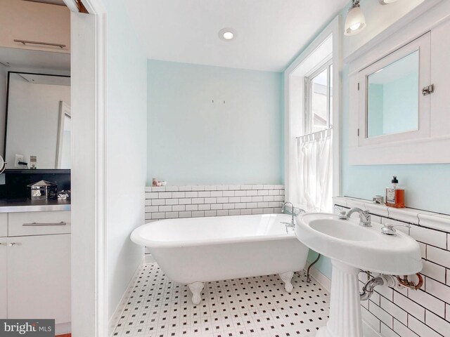 bathroom with a soaking tub, tile patterned floors, and recessed lighting
