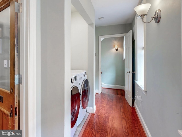 laundry area featuring washer and clothes dryer, wood finished floors, and baseboards