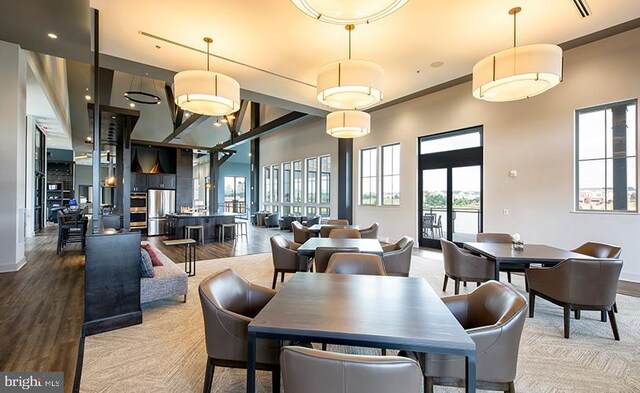 dining area featuring baseboards, wood finished floors, and a high ceiling