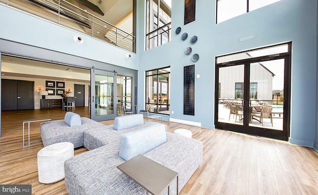 living room with wood finished floors and a towering ceiling
