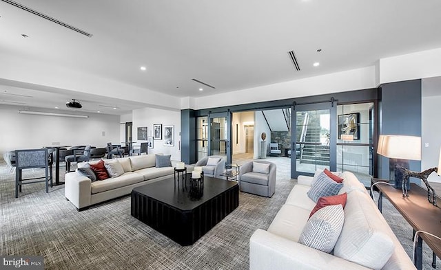 carpeted living area with visible vents, recessed lighting, a barn door, and stairway