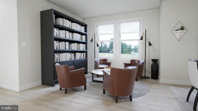 living area with baseboards and wood finished floors