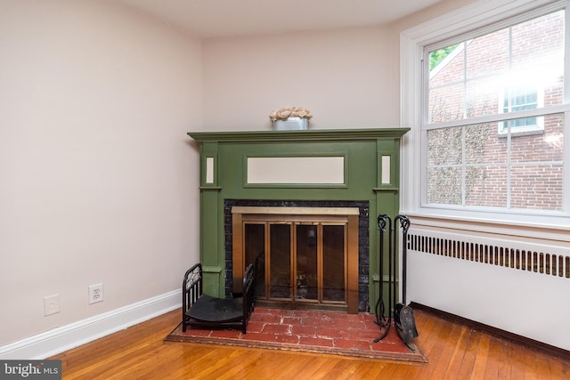 2948 Normandy Rd, Ardmore, PA 19003 - detailed view of radiator, wood finished floors, a glass covered fireplace, and baseboards