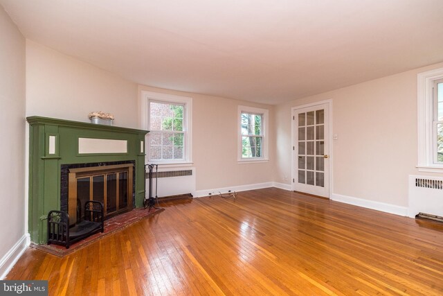 2948 Normandy Rd, Ardmore, PA 19003 - unfurnished living room featuring radiator heating unit, a glass covered fireplace, hardwood / wood-style floors, and baseboards