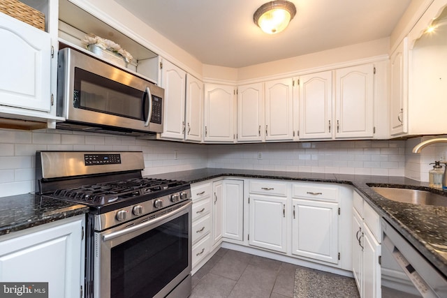 2948 Normandy Rd, Ardmore, PA 19003 - kitchen with stainless steel appliances, a sink, white cabinets, and dark tile patterned flooring