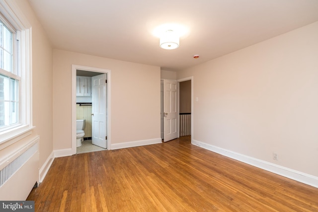 2948 Normandy Rd, Ardmore, PA 19003 - unfurnished bedroom with radiator heating unit, wood finished floors, baseboards, and multiple windows