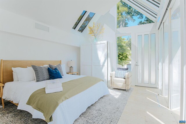 bedroom featuring light wood-style floors, a high ceiling, and visible vents