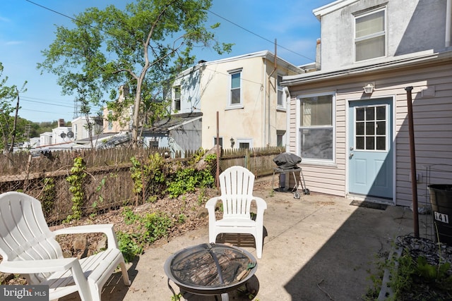 view of patio with an outdoor fire pit, fence, and a grill