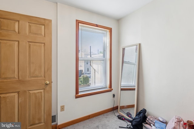 interior space with baseboards and carpet