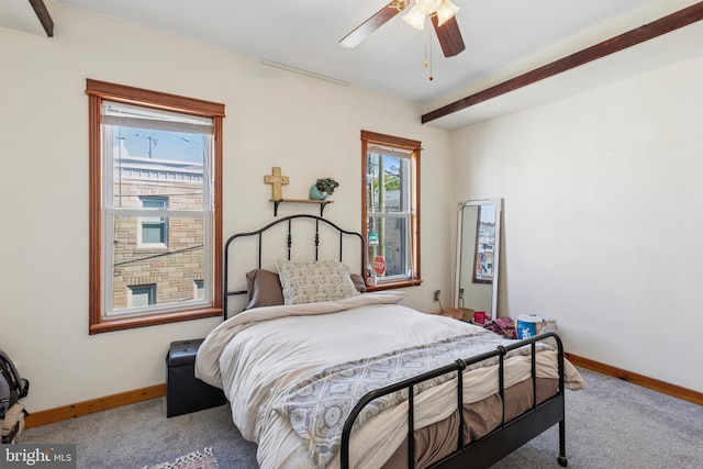 carpeted bedroom featuring a ceiling fan, baseboards, and multiple windows