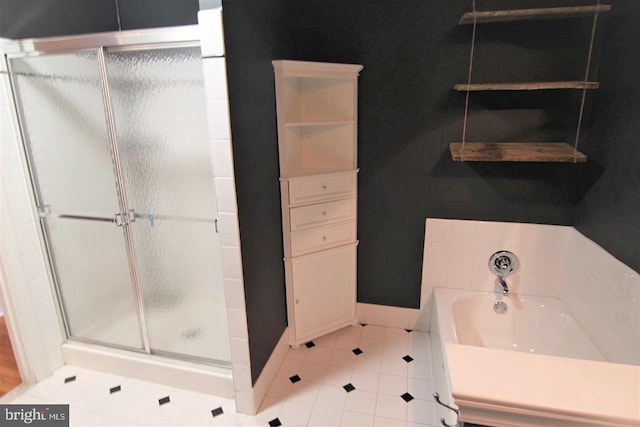 bathroom featuring tile patterned flooring, a shower stall, and a bath