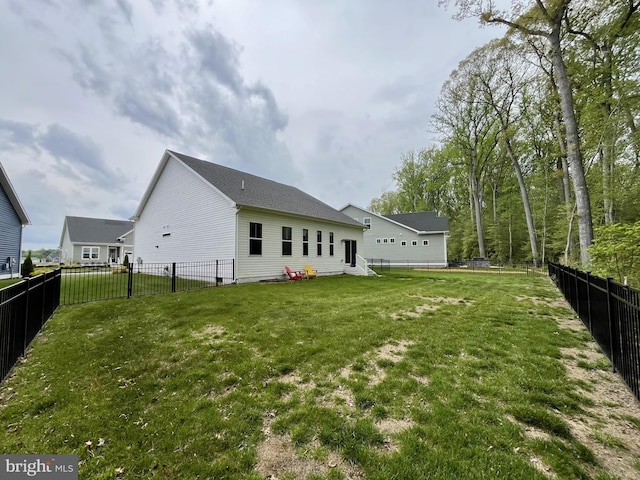 rear view of house with a lawn and a fenced backyard