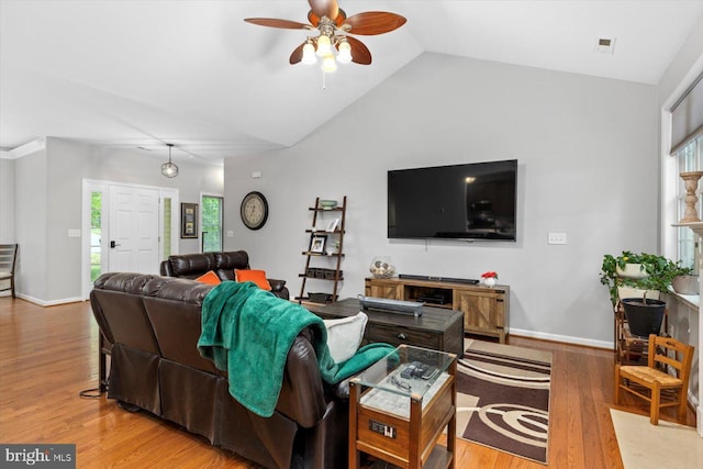living area featuring a ceiling fan, vaulted ceiling, plenty of natural light, and wood finished floors