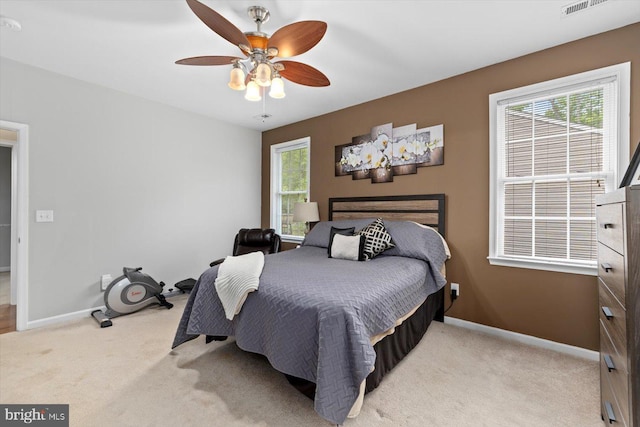 bedroom with a ceiling fan, baseboards, and light colored carpet