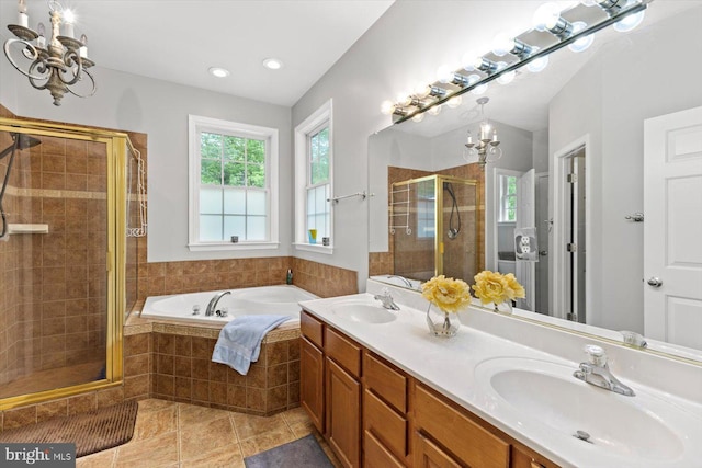 bathroom featuring an inviting chandelier, a sink, a bath, and a stall shower
