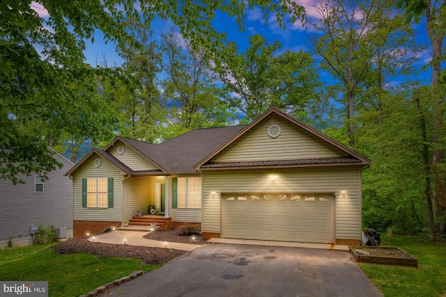view of front of home with an attached garage, a yard, and driveway