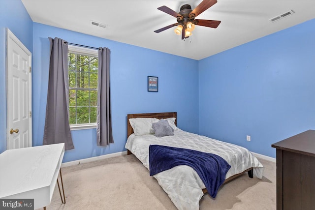 carpeted bedroom featuring baseboards, visible vents, and ceiling fan