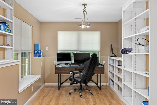 office area with baseboards, wood finished floors, and visible vents