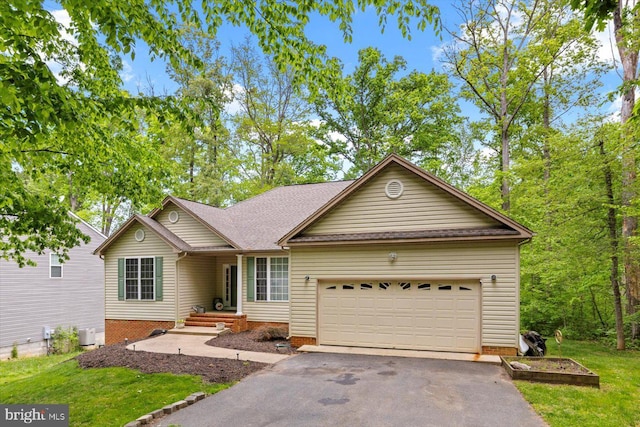 single story home with an attached garage, a front lawn, and aphalt driveway