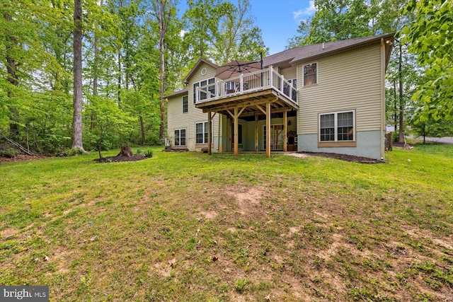 back of house featuring a lawn and a wooden deck