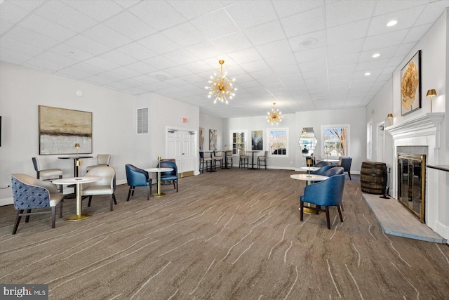 interior space with carpet flooring, baseboards, a notable chandelier, and visible vents