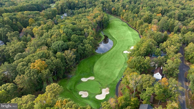 aerial view with a water view, a view of trees, and view of golf course