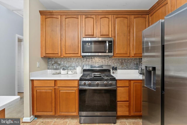 kitchen with light countertops, decorative backsplash, brown cabinets, and stainless steel appliances