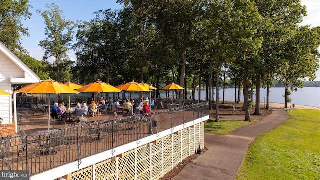 view of community featuring a water view and fence