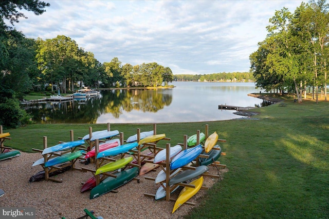 view of dock featuring a lawn and a water view