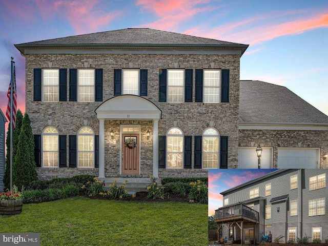 colonial inspired home with driveway, a front yard, brick siding, an attached garage, and a shingled roof