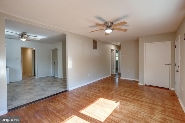 unfurnished room with a ceiling fan, baseboards, visible vents, and light wood-type flooring